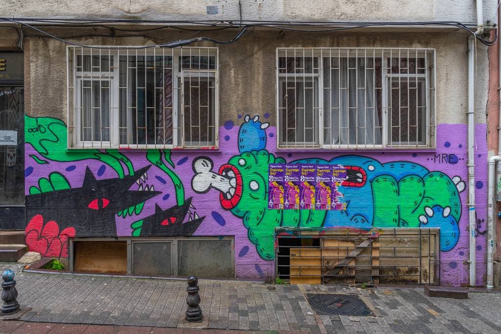 Intertwined Creatures on Purple Wall