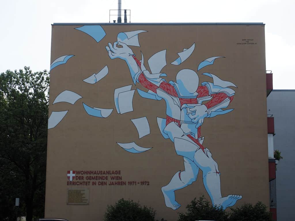"Dancing Blue Figure with Floating Papers" by Daan Botlek in Vienna