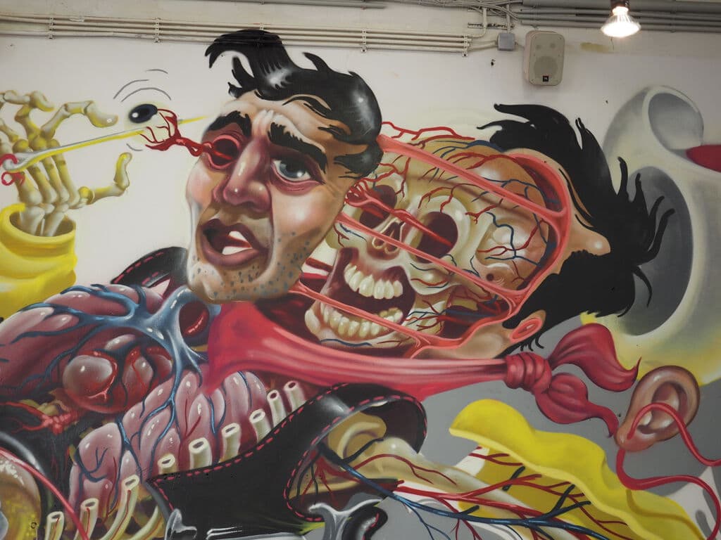 "Anatomical Horror Figure with Exposed Systems" by Nychos in Obere Windmhle, Vienna
